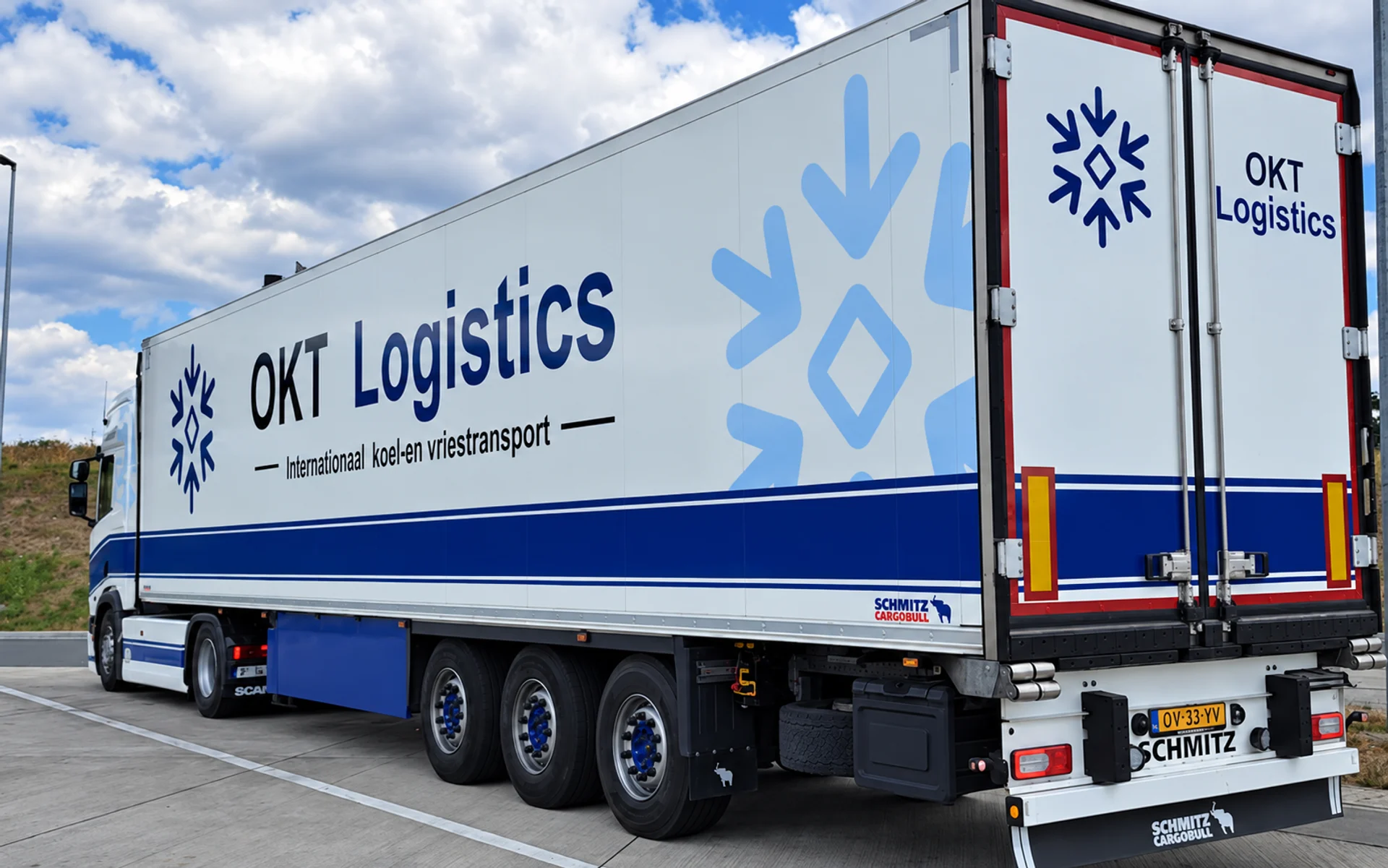 Zij- en achteraanzicht van een OKT Logistics koeltrailer